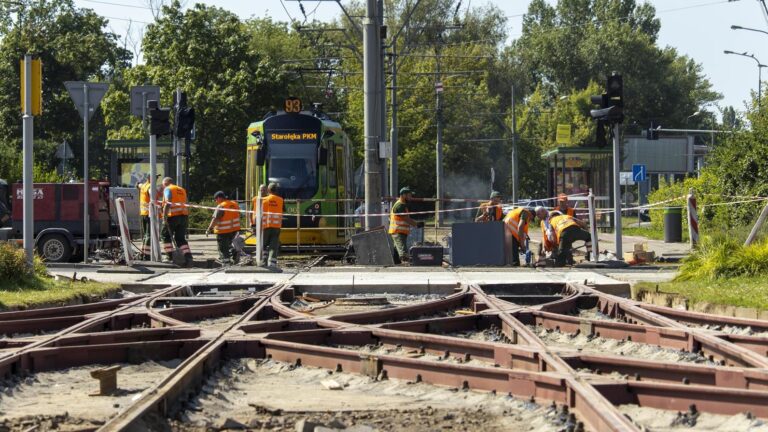 Nowo ułożone torowisko, w tle robotnicy i tramwaj