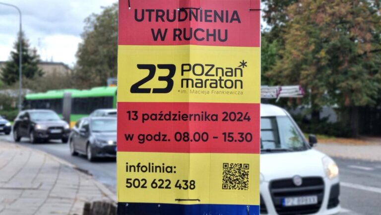 Informacja o utrudnieniach związanych z maratonem. Plansza przymocowana do przydrożnego słupa