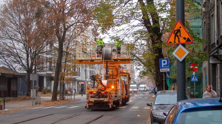 Wóz techniczny na torowisku. Dwaj mężczyźni na podnośniku